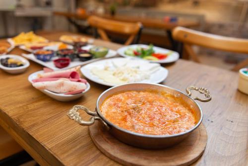 a table with a pot of soup and plates of food at Begonville Mansion Oldcity in Istanbul