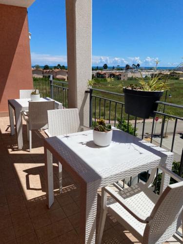 2 mesas blancas y sillas en un balcón con vistas en B&B Come a Casa en Citta' Sant'Angelo