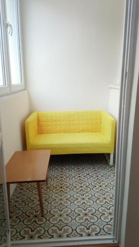 a yellow couch in a living room with a table at Apartament przy basenie in Giżycko