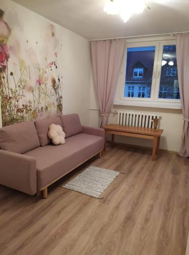 a living room with a couch and a window at Apartament przy basenie in Giżycko