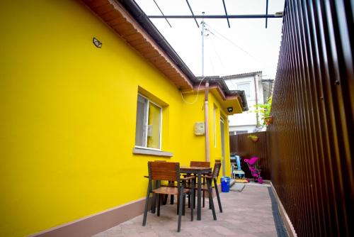 a yellow building with chairs and a table in front of it at Casa Lili in Mangalia