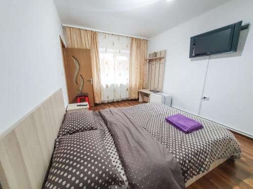 a bedroom with a bed with a purple pillow on it at Casa Lili in Mangalia
