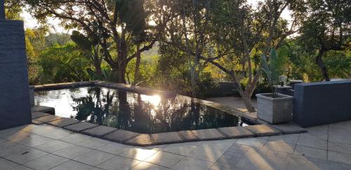 a pool of water in a yard with trees at Forget me not Selfcatering Apartments in Nelspruit