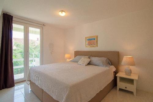 een slaapkamer met een bed en een groot raam bij Apartments Lilly in Banjole