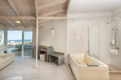 La salle de bains blanche est pourvue d'une baignoire et d'un lavabo. dans l'établissement Sunday Life, à Agia Pelagia