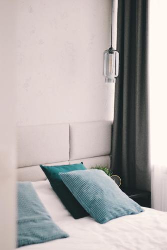 a bed with two green pillows on it at BOOGIE Home Kamienica Łódzka in Łódź