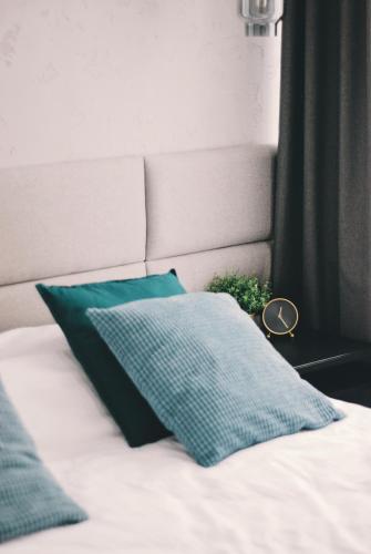 a bed with two green pillows on it at BOOGIE Home Kamienica Łódzka in Łódź