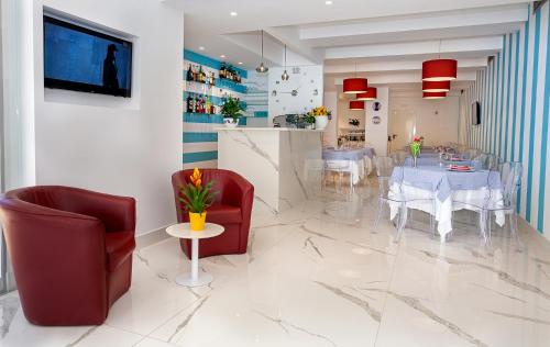 a dining room with red chairs and a white table at Hotel Angelina in Sant'Agnello