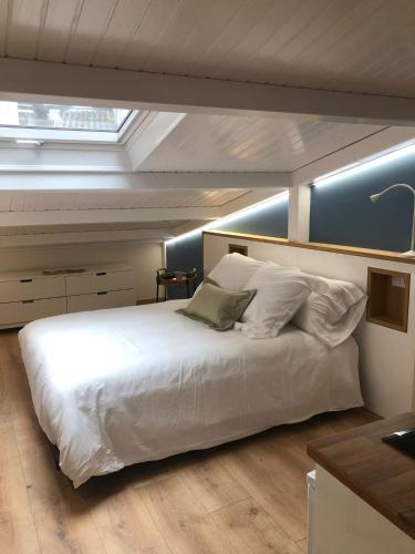 a bedroom with a large white bed with a skylight at Apartamento completamente equipado en Pontedeume. in Puentedeume