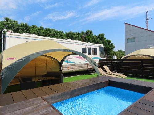 a tent and a swimming pool next to an rv at Osaka Hokko Marina HULL in Osaka