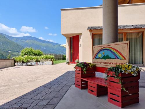 a building with a bench with a rainbow painting on it at Bio Agritur al Bait in Spormaggiore