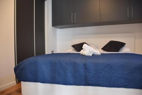 a blue and white bed with black and white pillows at Apartman Lucana in Tribunj