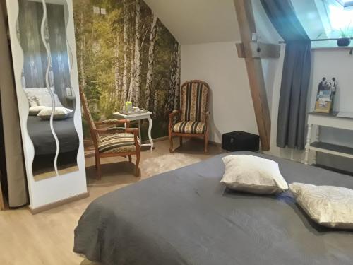 une chambre avec un lit, une table et des chaises dans l'établissement Atypiques Confitures, Chambres d'Hôtes, à Couffy