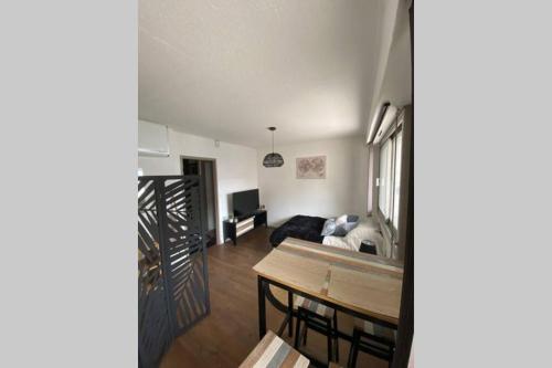 un salon avec une table et un canapé dans l'établissement Le 13 du temple - plein coeur centre ville, résidence privée, 5mn gare Sncf, WIFI et Netflix, à Niort