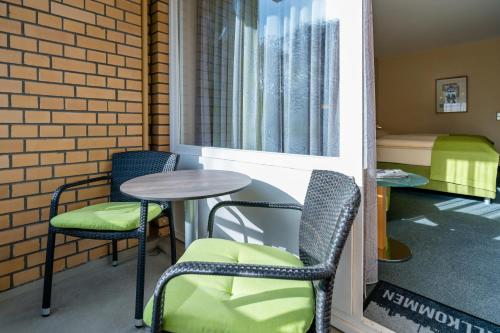 a room with two chairs and a table and a bed at Schlosspark Hotel in Berlin