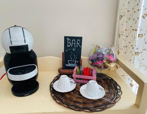 a coffee maker on a table next to a basket with cups at Archè in Salerno