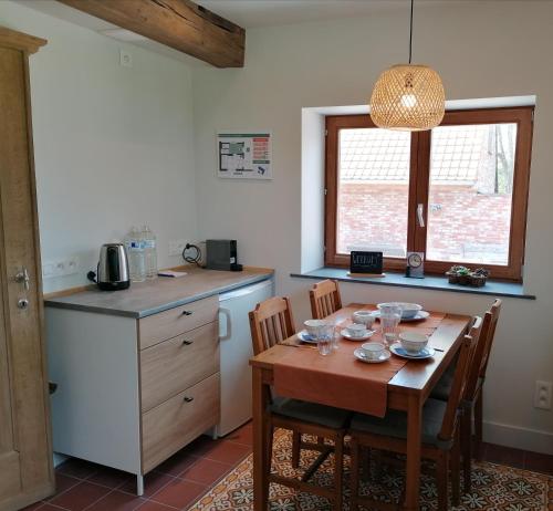 eine Küche mit einem Holztisch mit Stühlen und einem Waschbecken in der Unterkunft B&B Lekker Buiten in Stratendries
