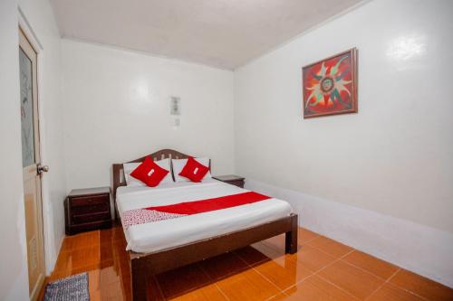 Un dormitorio con una cama con almohadas rojas. en OYO 741 Sierra Travellers Inn, en Tagaytay