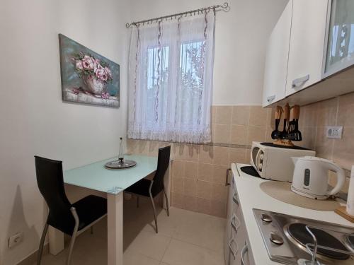 een kleine keuken met een tafel en stoelen en een magnetron bij Studio Apartment Mandic in Dubrovnik
