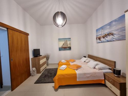 een slaapkamer met een bed met een gele deken bij Studio Apartment Mandic in Dubrovnik