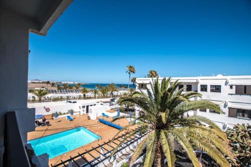 una vista aérea de un complejo con piscina y palmeras en Casa Coral with sea views & AC, en Puerto del Carmen