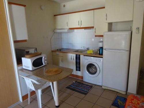 a small kitchen with a table and a microwave at Fare Arearea Sweet Studio in Papeete