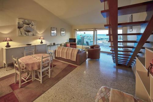 une cuisine et un salon avec une table et des chaises dans l'établissement SUPERBE DUPLEX IDEALEMENT SITUE PROCHE PLAGES AVEC GRANDE TERRASSE VUE PORT !l A1B59, à Cannes