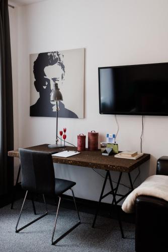 a desk in a room with a television and a chair at Sommers Hotel Altes Posteck in Reichenbach im Vogtland