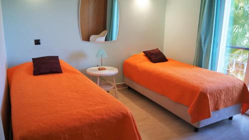 two orange beds in a room with a window at Apartamento Foz da Ria in Lagos