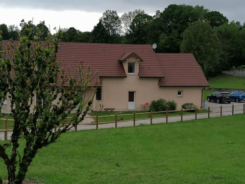 une maison avec un toit rouge et une clôture dans l'établissement Chez Catherine & Patrick, à Fontenu