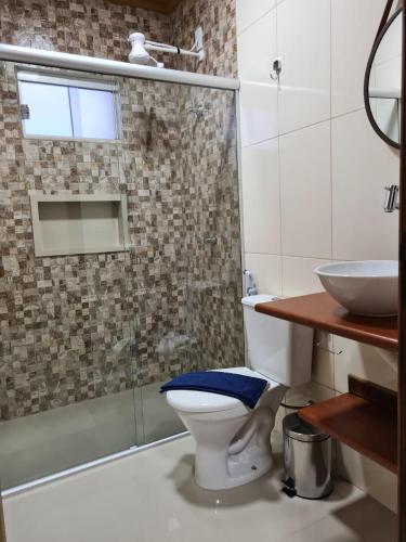 a bathroom with a toilet and a shower and a sink at Pássaros do Cerrado Suítes in Alto Paraíso de Goiás