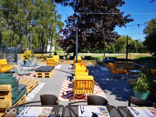 a group of yellow chairs and tables in a patio at Novotel Roissy Saint Witz in Saint-Witz