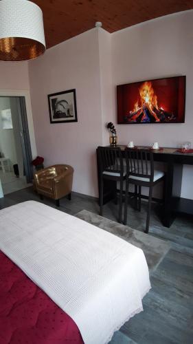 una camera con letto e tavolo con camino di Room De Lux SPA " TABARKA " a Spa