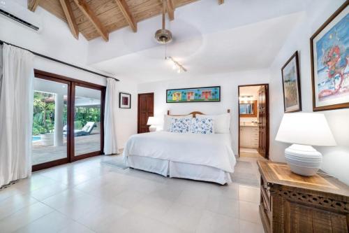 ein Schlafzimmer mit einem Bett und einem Tisch mit einer Lampe in der Unterkunft Los Lagos 19- Golf and Lake View 5-Bedroom Villa in La Romana