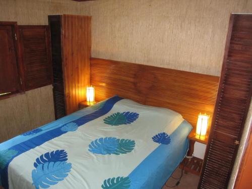 a bedroom with a bed with a blue blanket at Fare Arearea in Faaone