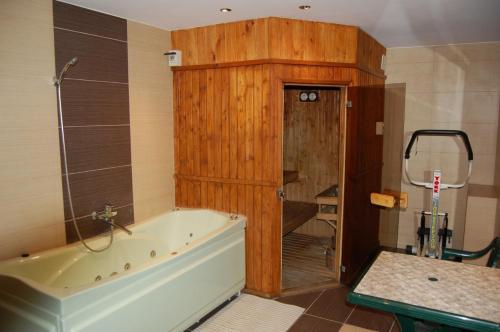 y baño con bañera y pared de madera. en Hotel Słupsk, en Słupsk