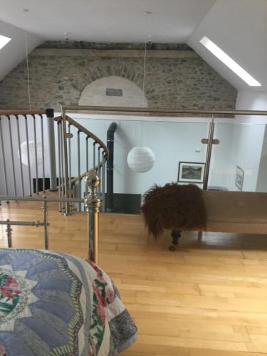 a living room with a couch and a staircase at Auld Skuil in Ashkirk