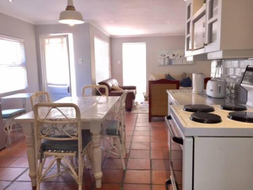 a kitchen with a table and chairs in a kitchen at Meerhuis Cottage in Langebaan