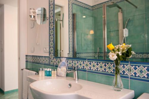 a bathroom with a sink and a vase of flowers at Hotel Panorama in Maiori