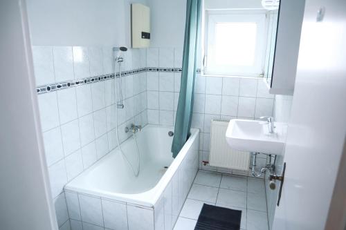 a white bathroom with a tub and a sink at Work & Travel in Remscheid
