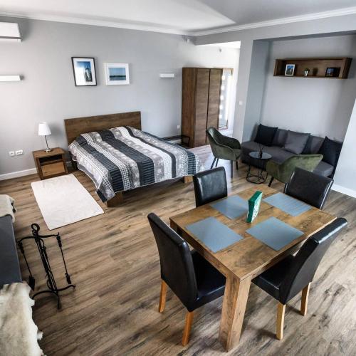a room with a bed and a table and chairs at Apartman277 Palić in Palić