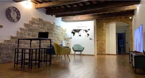 耶西的住宿－L'ANTICA FALCONERIA，配有桌椅和挂钟的墙壁的客房