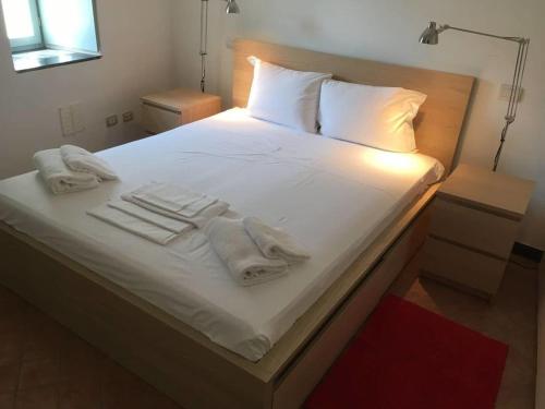 a bed with white blankets and towels on it at Stunning medieval setting surrounded by mountains in Castelbianco