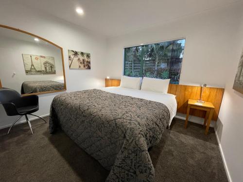 Habitación de hotel con cama y silla en Luxury Home Next to Ocean and Walkway en New Plymouth