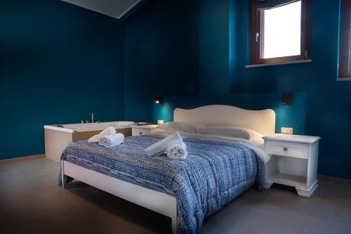 um quarto azul com uma cama com duas toalhas em Le Coccole em Guardiaregia