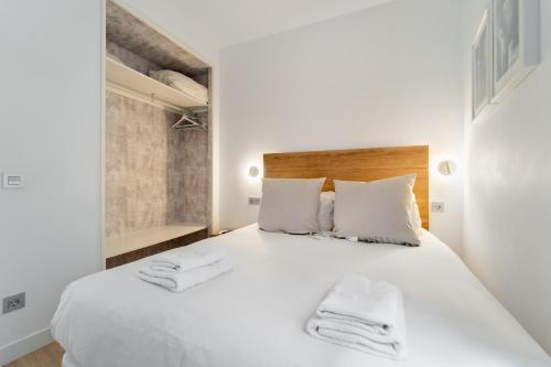 1 dormitorio con 1 cama blanca grande y 2 toallas en Minty Stay 1BD - Lavapies, en Madrid
