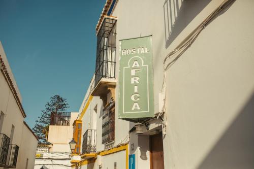a sign for a hotel on the side of a building at Hostal Africa in Tarifa