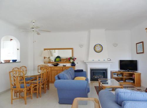 a living room with blue chairs and a fireplace at Casa Rosa Floresta in Luz