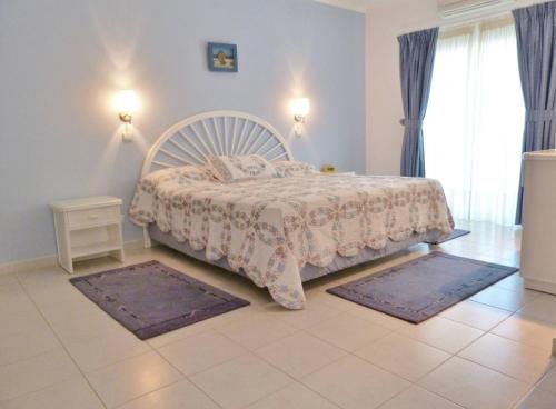 a bedroom with a bed with two rugs on the floor at Casa Rosa Floresta in Luz