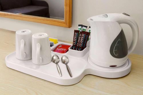 a white coffee maker sitting on a counter with spoons at Days Inn Sutton Scotney South in Sutton Scotney